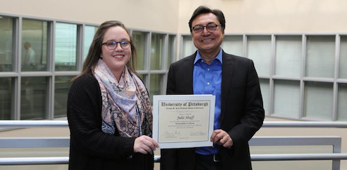 Professor and student hold certificate together