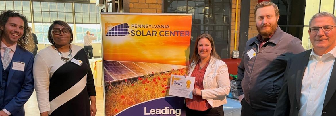 5 people standing in front of a sign that reads "Pennsylvania Solar Center"