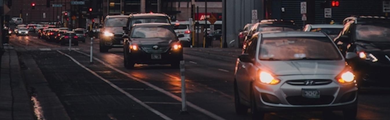 cars driving in the city streets at sunset